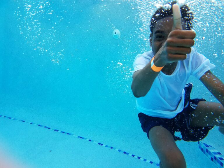 Junge unter Wasser zeigt den Daumen nach oben