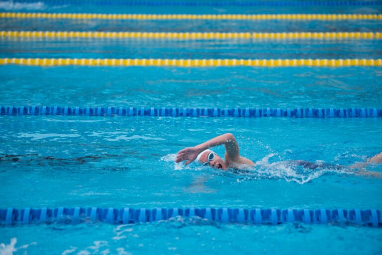 Frau schwimmt Kraul auf einer Bahn im Becken